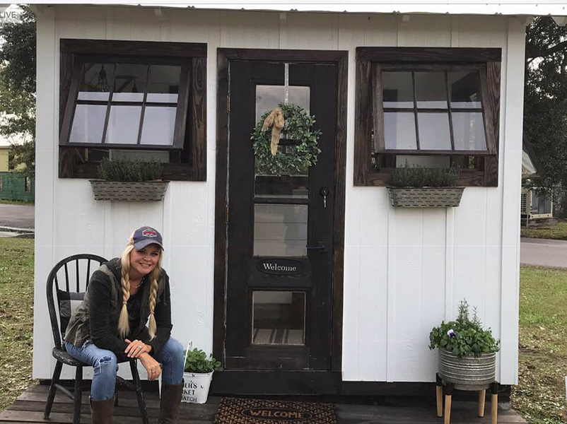 Holly Lemoine-Raymond in front of a tiny home